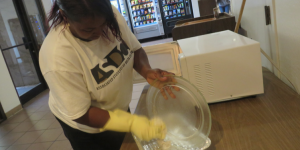 HELPING HANDS: Carmen Slaughter, above, cleans a microwave in Danner Hall. PHOTO BY ORLANDO JOSE