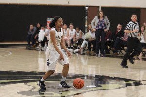 Tiara Tucker dribbles past half court as coach Johnson and team looks on at Joseph Blanchard Gymnasium. PHOTO BY RICHARD REYES 