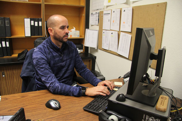 New athletic director Tony Espinoza at his desk in his office in the Budd center.