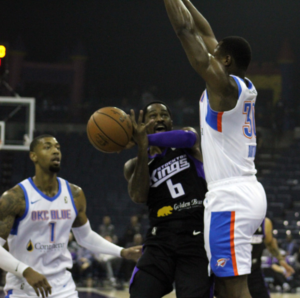 Kings Kalin Lucas attempting to shoot but getting shoved by Blues player.