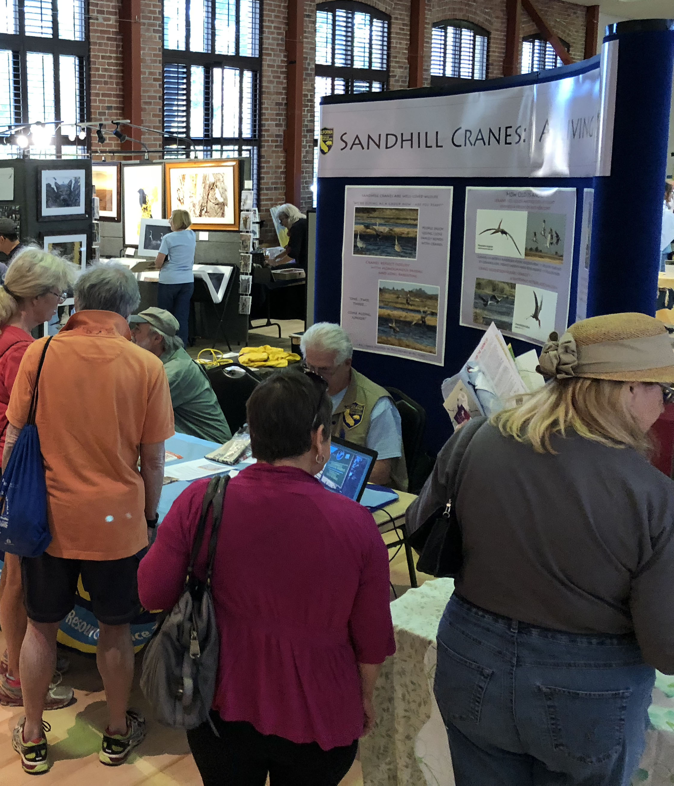 Festival members gather around the exhibit hall to get information about the migration of cranes to the San Joaquin Delta area.