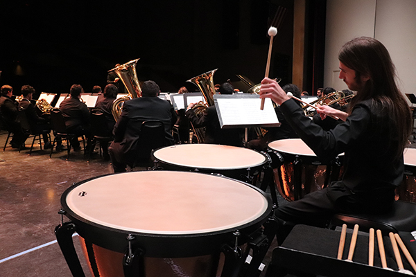 Robin Bisho plays percussion behind all of the Symphonic Band during “A Zillion Nickles” by Samuel Hazo