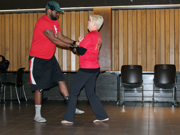 Byrd prompting a student to hold her wrists tighter to show how effortlessly she can get free.