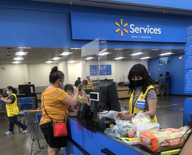 A plastic screen separates a customer from an employee at the Walmart Supercenter at Trinity Parkway in Stockton on. April 26. The screens are intended to ensure safety of all frontline essential workers responding to the COVID-19 pandemic. Photo by Robyn Jones.
