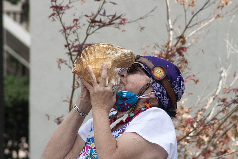 Linda Garcia Medina blows into a ceremonial conch to signal the start of the event.