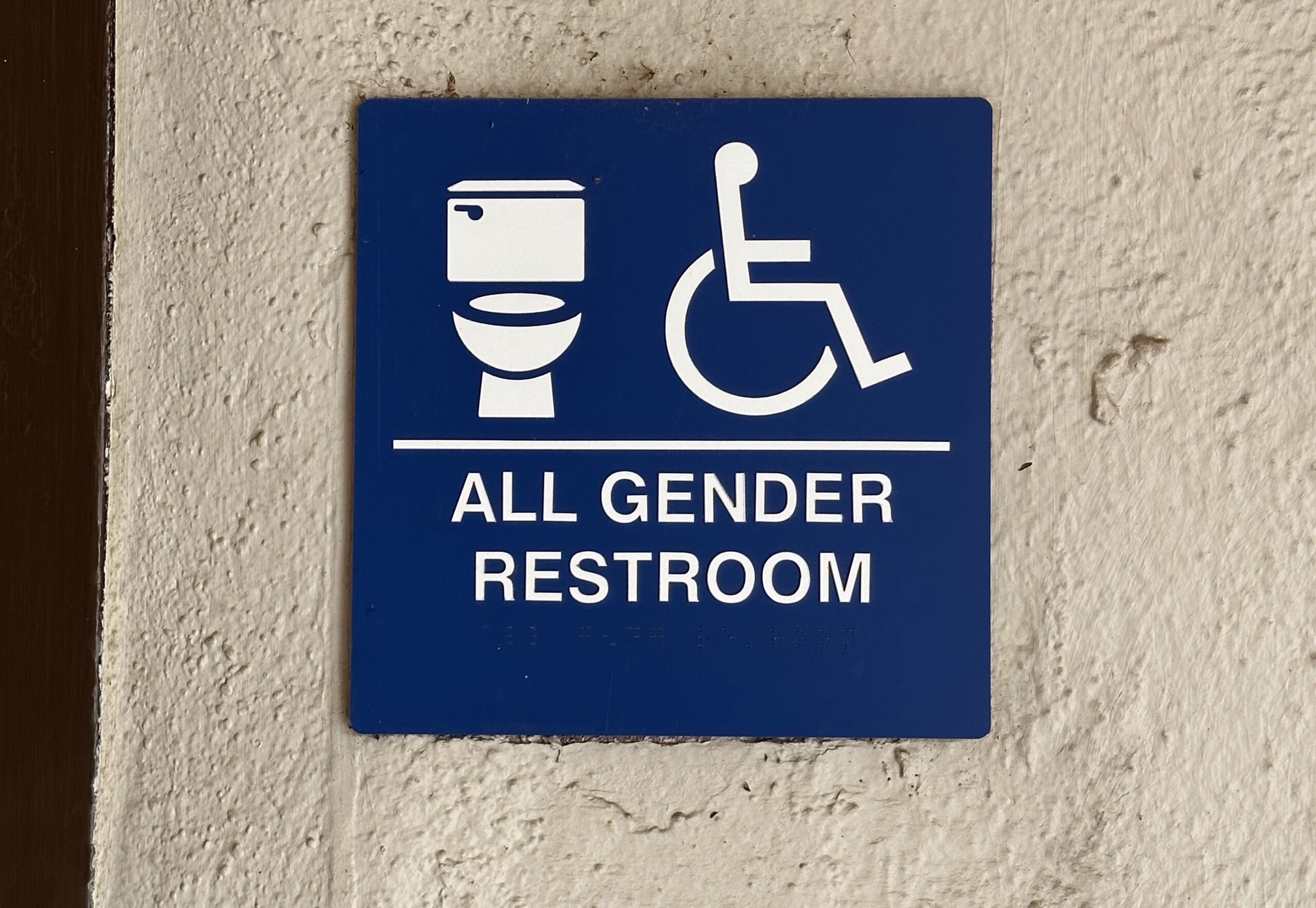 A sign for an all gender restroom on the first floor of the Shima building