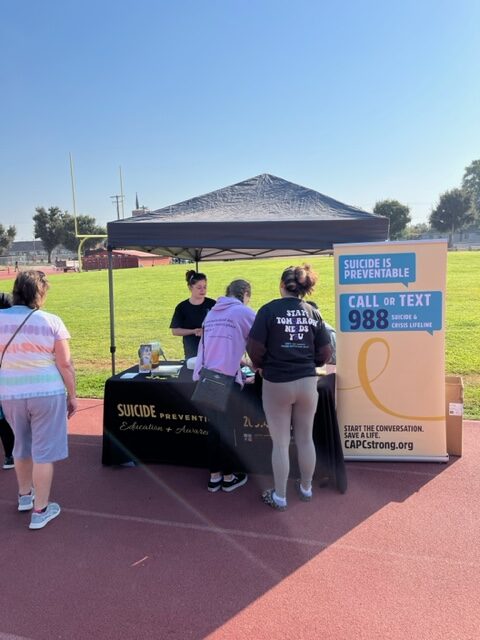Suicide Prevention Walk-out attendees speak with and receive information from representatives of the Child Abuse Prevention Council (CAPC). PHOTO BY DOMINICK DELISE