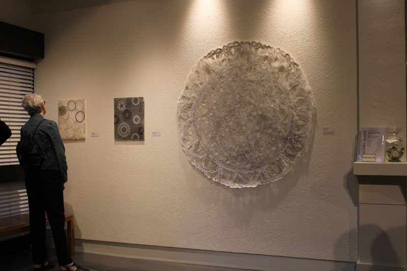Featured artist Lori Murphy, left, looks at works displayed at the LH Horton Gallery's "Singing to the Difference: An Examination of Surface Strategies" exhibit on March 7. PHOTO BY GRACE LAWSON