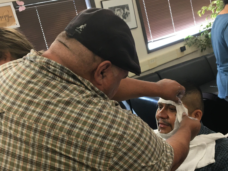 Jesus Barela applying plaster to Ricardo Aguilar Rodriguez’s, using him as a face model for the masks. PHOTO BY JOHN NGUYEN