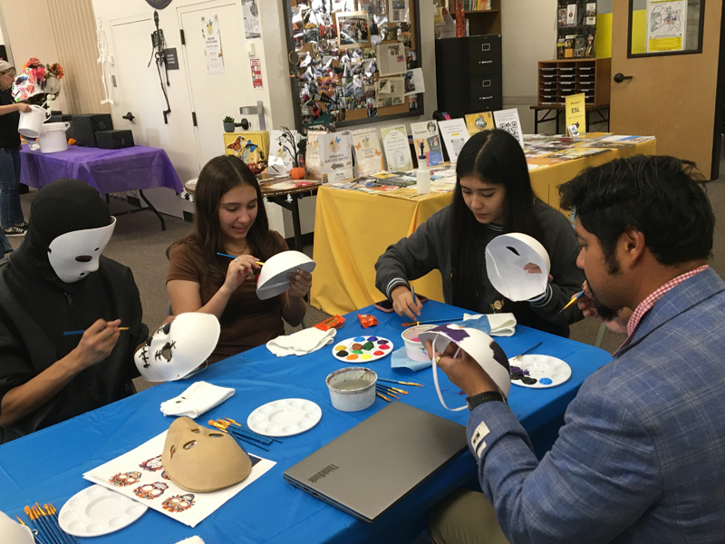 Guests at the Dia Del los Muertos painting their masks at the workshop tables. PHOTO BY JOHN NGUYEN