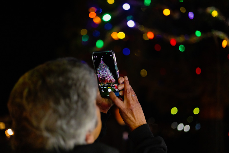 Family and friends gather to honor their loved ones through the Tree of Lights ceremony. Community members come together to capture memories of the display during the Stockton Tree Lighting Ceremony held on campus in Stockton on Nov. 26. PHOTO BY LAYLA CARRASCO