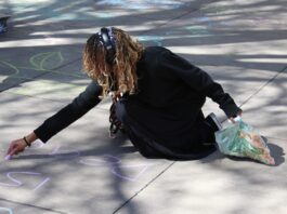 A Delta Student makes chalk art on the quad pavement for Inclusion Revolution event