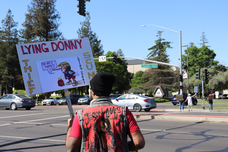 Protester with "Lying Donny" sign, depicting President trump as a Pinnochio, on the west side of Pacific and Yokuts.