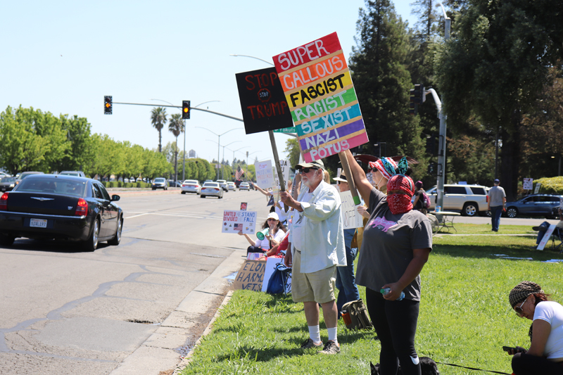 Protesters lined up along pacific avenue holding signs critical of president Donald Trump