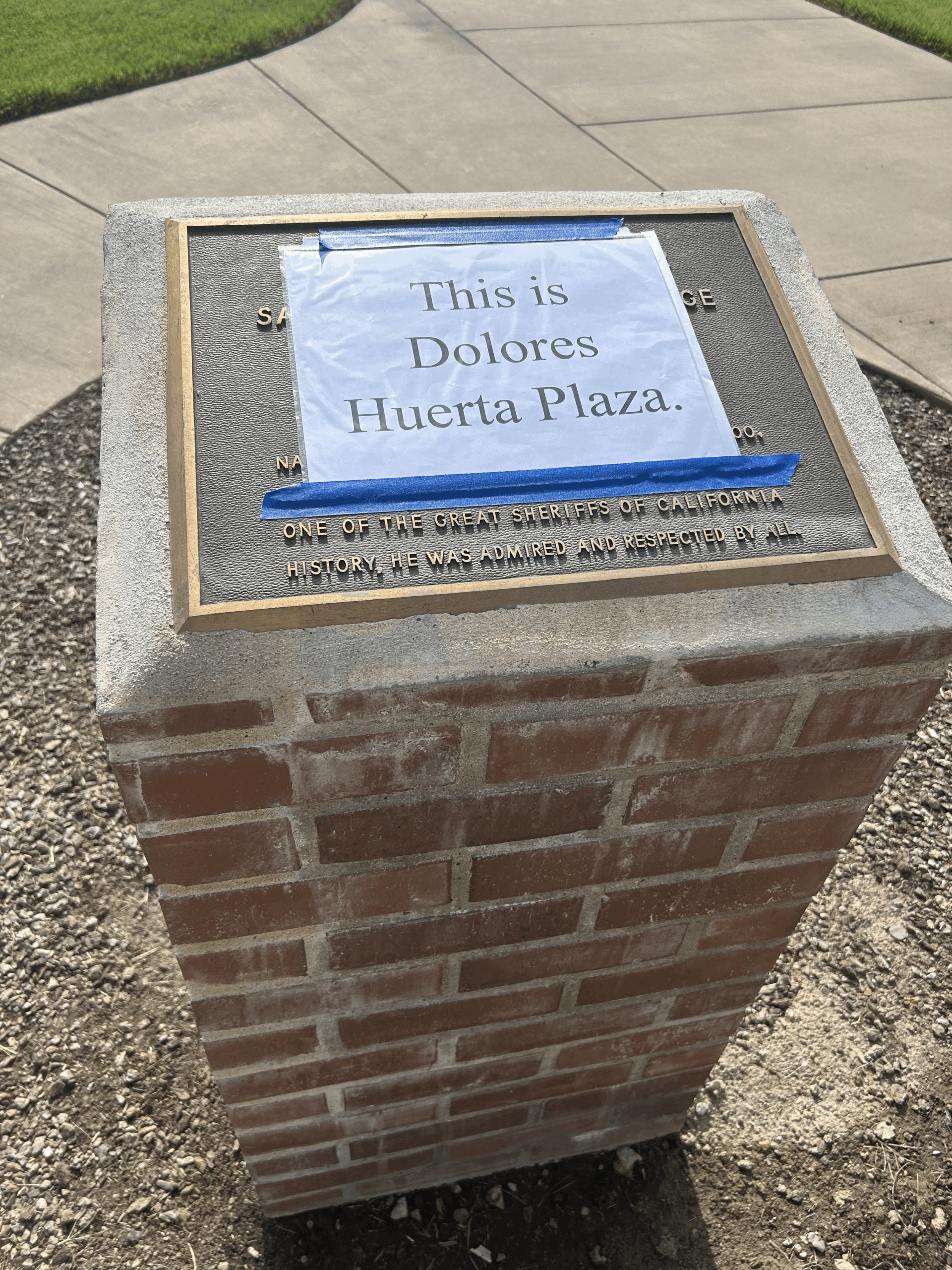 The Cunningham plaque covered by a paper reading "This is Dolores Huerta Plaza" on April 11. PHOTO COURTESY OF TARA CUSLIDGE-STAIANO.