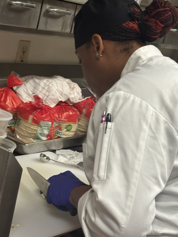 Nikki cutting what appears to be some garlic (photo taken by Jacob S Manglinong of MCOM 10)