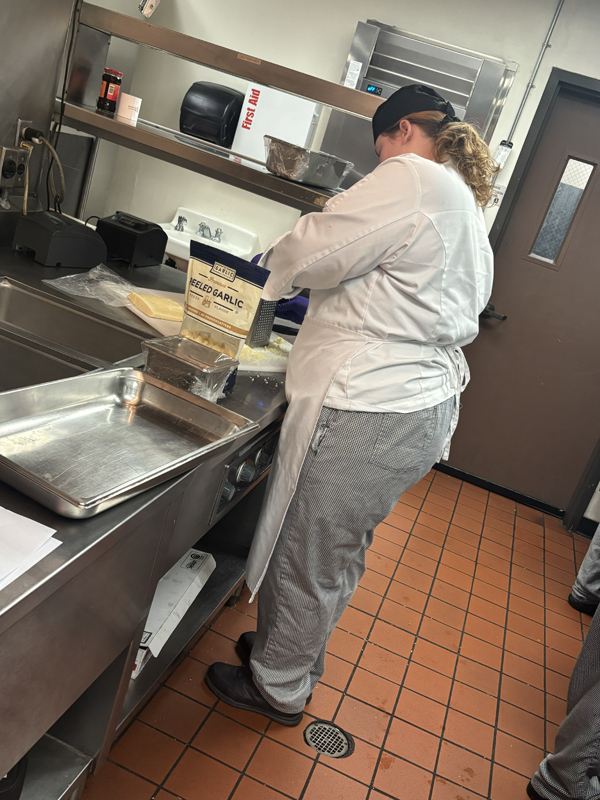 Angelina grating some parmesan cheese for a dish called Arancini (photo taken by Jacob S Manglinong of MCOM 10)