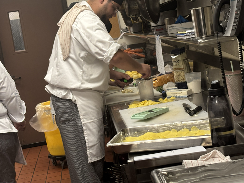 Jacob is grating what appears to be some garlic (photo taken by Jacob S Manglinong of MCOM 10)