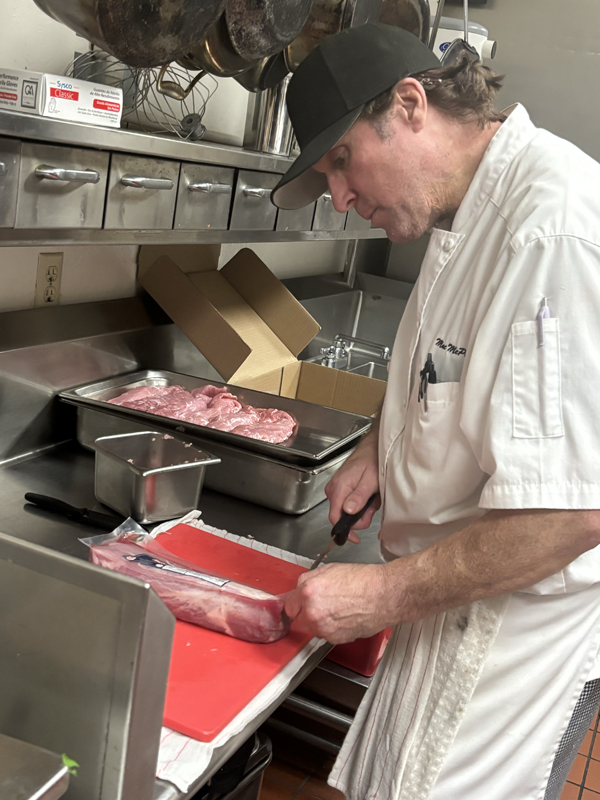 Max is readying himself to cut a piece of pork (photo taken by Jacob S Manglinong of MCOM 10)