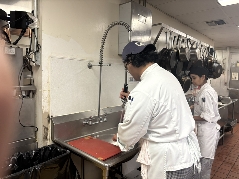 Anthony is washing some dishes (photo taken by Jacob S Manglinong of MCOM 10)